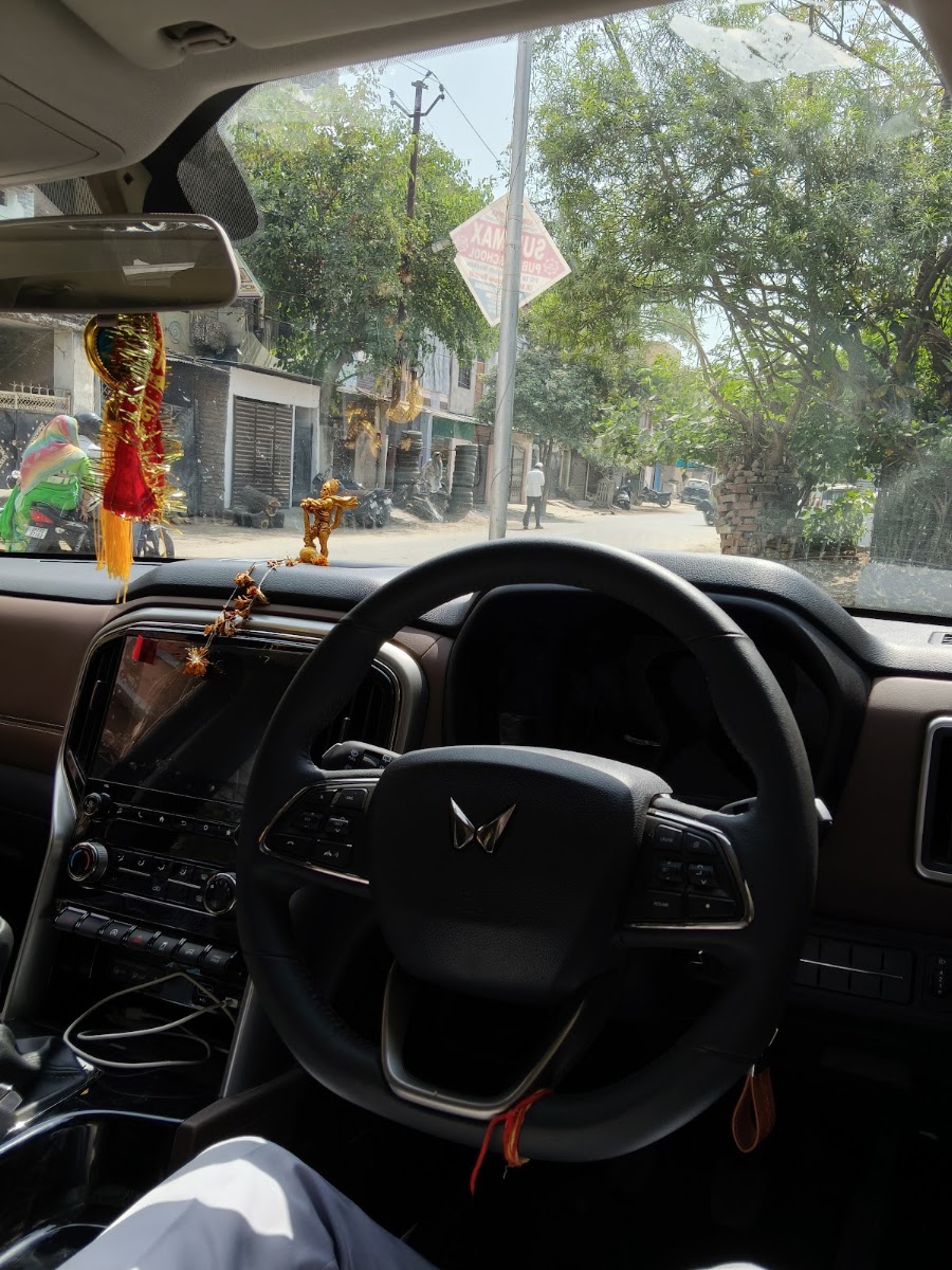 Driver in uniform operating customer car in Lucknow traffic