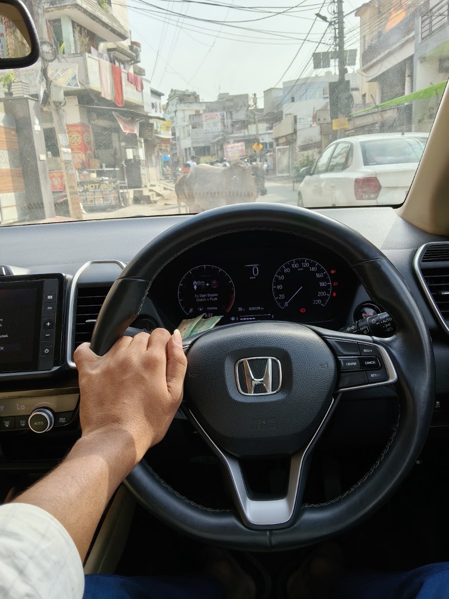 Driver navigating Honda City through Lucknow morning traffic